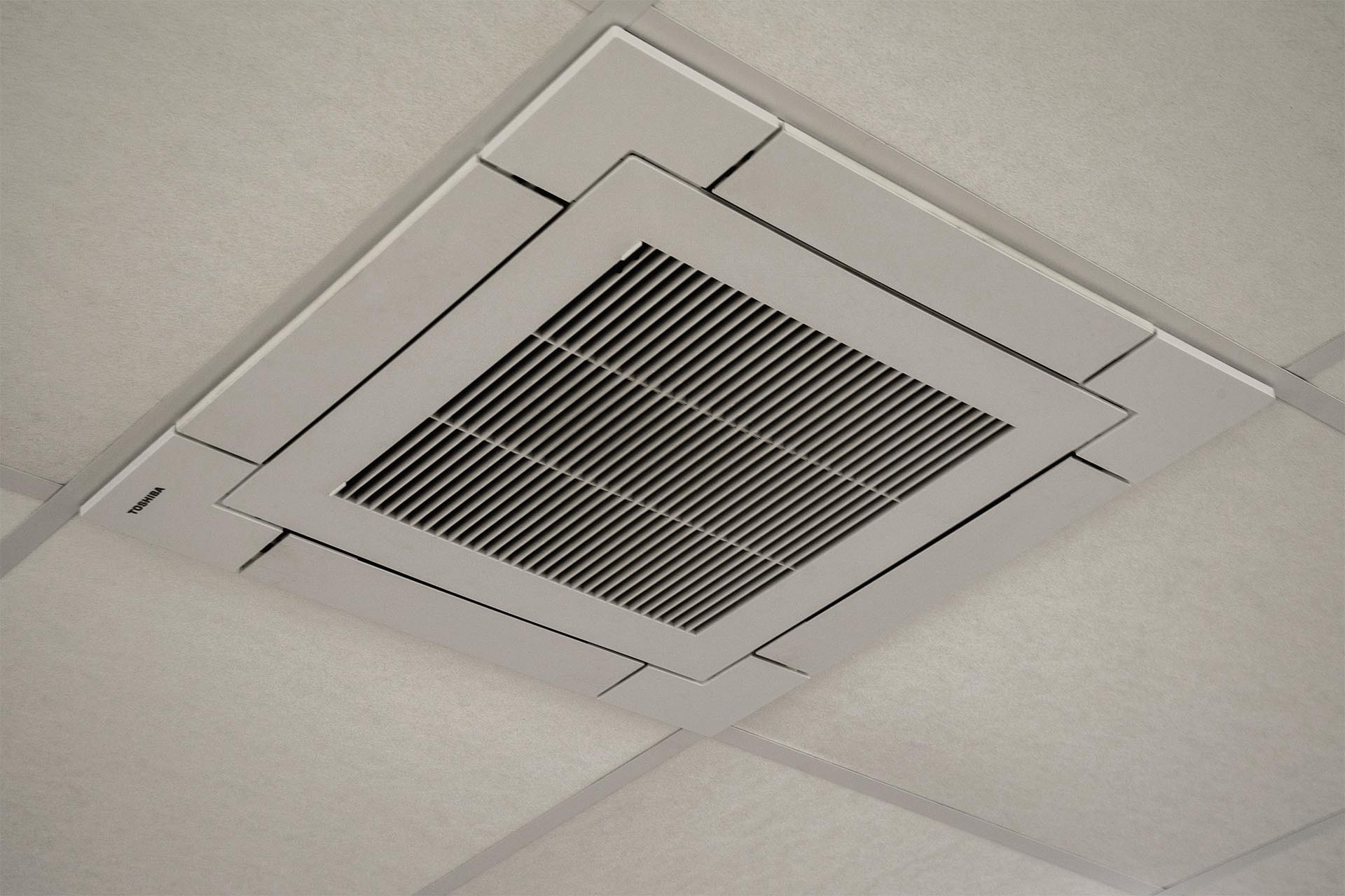 An der Decke montiertes Toshiba-Klimagerät in einem hellen Raum